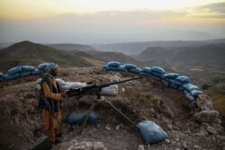In this picture taken on July 11, 2021 an Afghan militia fighter keeps a watch at an outpost against Taliban insurgents at Charkint district in Balkh Province.