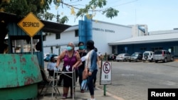 Un paciente camina con una familiar tras realizar una consulta en el Hospital Alemán Nicaraguense durante el mayor brote de coronavirus en abril del 2020.