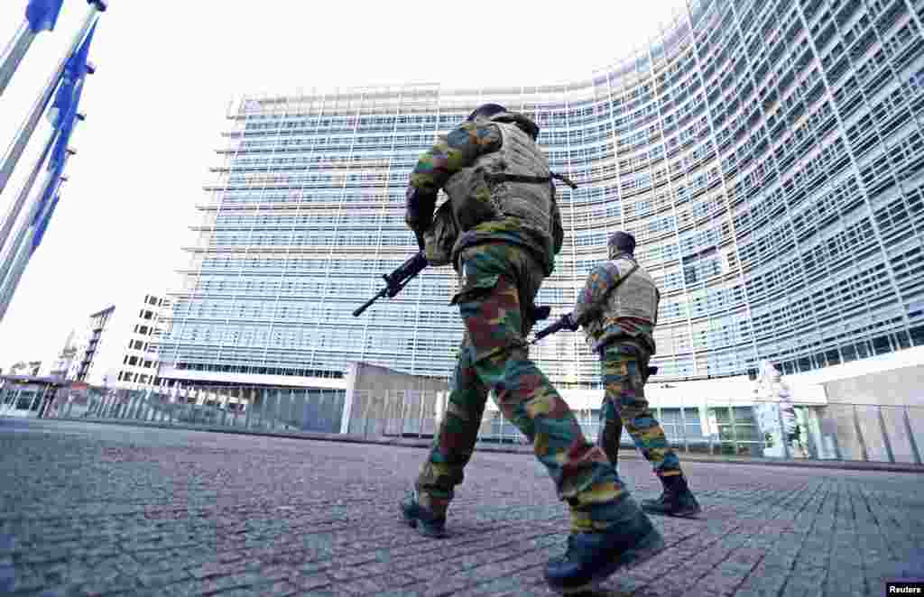 Belgian soldiers patrol outside the European Commission headquarters as police searched the area during a continued high level of security following the recent deadly Paris attacks, in Brussels.