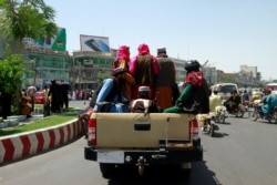 Taliban fighters sit on the back of a vehicle in the city of Herat, west of Kabul, Afghanistan, Saturday, Aug. 14, 2021, after they took this province from Afghan government.