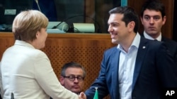 Greek Prime Minister Alexis Tsipras, right, shakes hands with German Chancellor Angela Merkel during a round table meeting at the EU-CELAC summit in Brussels on Wednesday, June 10, 2015.