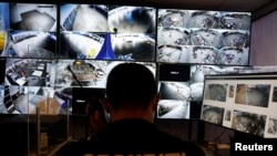 Seorang petugas keamanan memonitor kamera pengawas untuk mengawasi kerumunan orang di Changi Exhibition Center di tengah pandemi virus corona di Singapura, 3 Juni 2020. (Foto: Reuters)