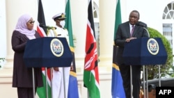 Kenya's President Uhuru Kenyatta, right, listens as Tanzanian President Samia Suluhu Hassan speaks during a joint press conference at the State House in Nairobi, May 4, 2021. 