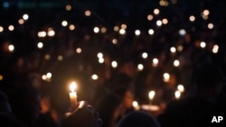 FILE - Attendees hold up their candles at a candlelight vigil for the victims of the shooting at Marjory Stoneman Douglas High School, in Parkland, Florida, Feb. 15, 2018. 