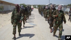 FILE - Members of Somalia's al-Shabab militant group patrol on foot on the outskirts of Mogadishu, Somalia, March 5, 2012. 
