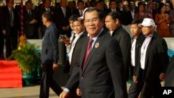 Cambodian Prime Minister Hun Sen, center, arrives for a ceremony of the 68th anniversary of the founding of his Cambodian People's Party in Phnom Penh, Cambodia, Friday, June 28, 2019. (AP Photo/Heng Sinith)