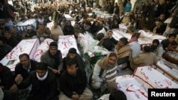 Shi'ite Muslims display the unburied coffins of victims of Thursday's twin bomb attack during a sit-in in Quetta, January 12, 2013.