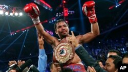 Manny Pacquiao from the Philippines wears the champion's belt after defeating Brandon Rios of the United States in the WBO international welterweight title fight, Nov. 24, 2013, in Macau.