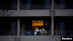 FILE - WHO virus expert Peter Ben Embarek, a member of the World Health Organization team tasked with investigating the origins of the coronavirus disease, receives a swab test on the balcony of a hotel in Wuhan, Hubei province, China, Feb. 3, 2021.