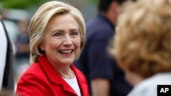 FILE - Democratic presidential candidate Hillary Rodham Clinton greets a spectator at a Fourth of July parade, July 4, 2015, in Gorham, New Hampshire.