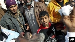 A wounded Libyan is taken into a hospital in the eastern oil port of Brega, Libya, after opponents of Moammar Gadhafi repelled an attack by the Libyan leader's forces trying to retake the coastal oil installation in a topsy-turvy battle in which a warplan
