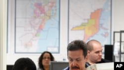 Workers scan in boxloads of absentee ballots. At issue are absentee ballot request forms the three counties have mailed to most registered voters pre-filled with information, including names, dates of birth and a voting pin number that few people know.