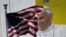 FILE - The U.S. flag flies in front of a mural of Pope Francis on the side of a building in midtown Manhattan in New York, Aug. 28, 2015.