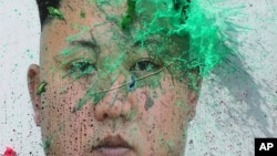 Người đào tị Bắc Triều Tiên ném bóng chứa sơn lên chân dung lãnh tụ Kim Jong Un trong một cuộc biểu tình phản đối Bình Nhưỡng tại Seoul, ngày 30 tháng 3, 2016.