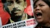 Seorang pengunjuk rasa meneriakkan slogan sambil mengacungkan poster aktivis HAM, Munir Said Thalib, dalam demonstrasi di luar kantor Badan Intelijen Nasional (BIN), di Jakarta, 7 September 2007. 