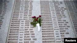 FILE - A memorial plaque lists victims' names, in the Srebrenica-Potocari Genocide Memorial Center, Bosnia and Herzegovina, June 8, 2021.