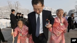 FILE - A North Korean man escorts his relatives as they reunite with their South Korean family members at Diamond Mountain resort in North Korea, Feb. 21, 2014.
