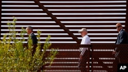 FILE - Attorney General Jeff Sessions, center, tours the U.S.-Mexico border with border officials in Nogales, Arizona, April 11, 2017. A courthouse on the border in Texas is serving as a model for the kind of tough immigration enforcement advocated by President Donald Trump.
