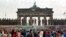 FILE - East Berlin border guards stand atop the Berlin Wall in front of the Brandeburg Gate on November 11, 1989.