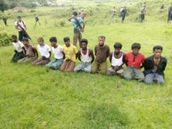 FILE - Rohingya men with their hands bound kneel as members of Myanmar security forces stand guard in Inn Din village, Rakhine state, Myanmar, Sept. 2, 2017.