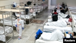 Nhân viên y tế mặc trang phục bảo hộ thăm khám bệnh nhân tại Trung tâm Triển lãm Hội nghị Quốc tế Vũ Hán, nơi được biến thành bệnh viện dã chiến để tiếp nhận bệnh nhân bị nhiễm virus corona.