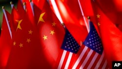 American flags are displayed together with Chinese flags on top of a trishaw in Beijing, Sept. 16, 2018. 