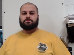 George Pierre Tanios stands for a booking photograph released by the West Virginia Regional Jail &amp; Correctional Facility Authority, March 14, 2021.