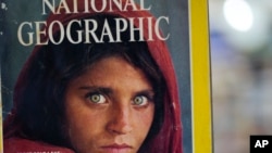 Pakistan's Inam Khan, owner of a book shop shows a copy of a magazine with the photograph of Afghan refugee woman Sharbat Gulla, from his rare collection in Islamabad, Pakistan, Oct. 26, 2016. 
