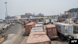 Des camions en file indienne au port de Lagos, le 31 janvier 2018. / AFP PHOTO / Stefan HEUNIS