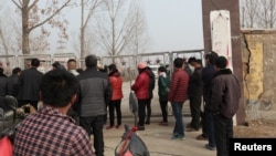 Warga setempat berdiri di luar komplek tambang yang roboh di provinsi Shandong, China timur Jumat (25/12).