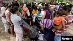 Central American migrants receive donated clothes as they take a break from traveling in their caravan, on their journey to the U.S., in Matias Romero, Oaxaca, Mexico, April 3, 2018. 