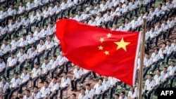 FILE - Students attend the 100th anniversary of the founding of Wuhan High School on the first day of the new semester in Wuhan, in China's central Hubei province, Sept. 1, 2020.