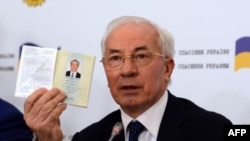 Ukraine's former prime minister, Mykola Azarov, displays his Ukrainian internal passport at a press conference in Moscow, August 3, 2015