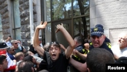 Protesters storm the office of LGBT+ campaigners at a rally against the planned March for Dignity during Pride Week in Tbilisi, Georgia, July 5, 2021. 