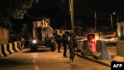 FILE - Police officers of the African Union's peacekeeping mission in Somalia (AMISOM) patrol on a street in Mogadishu, Somalia, Sept. 17, 2019. The country is bracing for attacks by the al-Shabab terror group during upcoming elections.