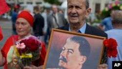 រូបឯកសារ៖ ក្រុម​អ្នក​គាំទ្រ​បក្ស​កុម្មុយនិស្ត​រុស្ស៊ី កាន់​រូប​ថត​លោក Josef Stalin មេដឹកនាំ​សូវៀត ដើម្បី​រំឭក​ខួប​ទី​៧១​នៃ​ជ័យ​ជម្នះ​លើ​ប្រទេស​ជប៉ុន​ក្នុង​សង្គ្រាម​លោក​លើក​ទី២ នៅ​ទីក្រុង​មូស្គូ ប្រទេស​រុស្ស៊ី កាល​ពីខែ កញ្ញា ​ឆ្នាំ​២០១៧។