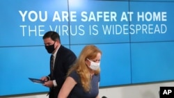 Arizona Gov. Doug Ducey and Dr. Cara Christ leave after providing an update on the COVID-19 situation in the state, June 29, 2020, in Phoenix. 
