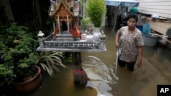 FILE - A Thai resident wades through a flooded area in Bangkok, Thailand, Oct. 3, 2011. Floods account for most of all disaster-related funding.
