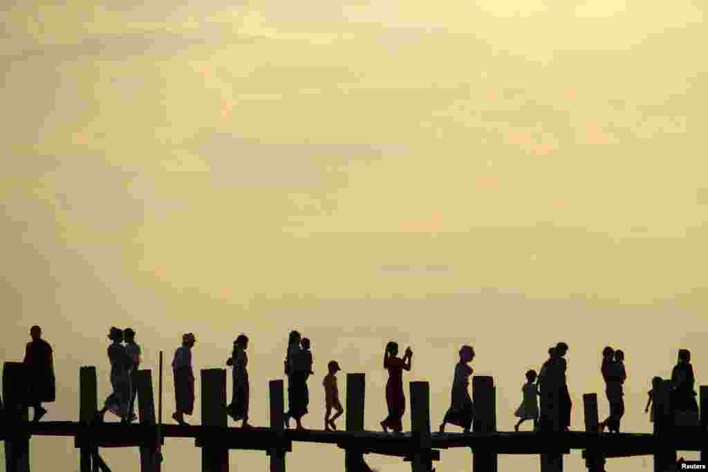 People cross U Bein bridge over Tuangthaman Lake in Mandalay, Myanmar.