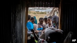 FILE - Tigrayans stand in line to receive food donated by local residents at a reception center for the internally displaced in Mekele, in the Tigray region of northern Ethiopia, on May 9, 2021. 