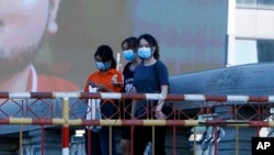 រូបឯកសារ៖ ស្ត្រីមួយក្រុមដែលមានពាក់ម៉ាស់ការពារការឆ្លងជំងឺកូវីដ១៩ ដើរកាត់បដាពាណិជ្ជកម្មមួយនៅតំបន់កោះពេជ្រ រាជធានីភ្នំពេញ កាលពីថ្ងៃសៅរ៍ ទី២០ ខែកុម្ភៈ ឆ្នាំ២០២១។