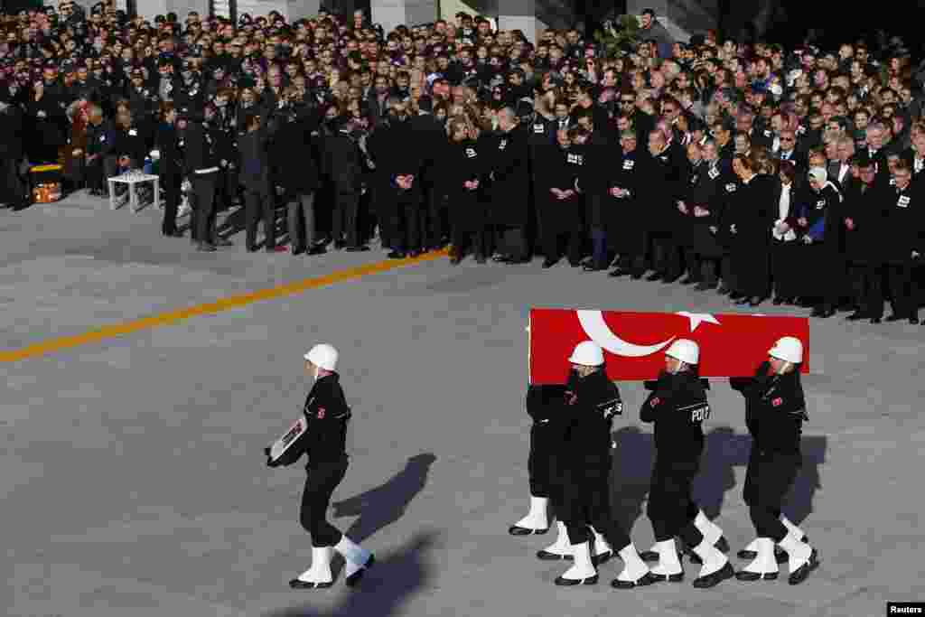 Turkish police officers carry a coffin of a fellow officer during a ceremony for police officers killed in Saturday&#39;s blasts in Istanbul, Dec. 11, 2016.