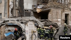 কিয়েভে রাশিয়ার ক্ষেপণাস্ত্র হামলায় ক্ষতিগ্রস্ত ভবনে উদ্ধারকারীরা কাজ করছে। ফটোঃ ২৫ মার্চ, ২০২৪। 