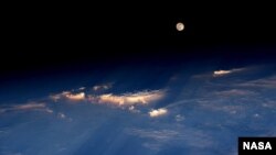 FILE - Expedition 48 Commander Jeff Williams of NASA took this photograph on June 21, 2016, from the International Space Station, writing, "A spectacular rise of the full moon just before sunset while flying over western China."