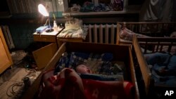 Orphaned children sleep inside cribs at the children's regional hospital maternity ward in Kherson, southern Ukraine, Tuesday, Nov. 22, 2022.