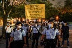Police officers disperse people mourning at Victoria Park on the 32nd anniversary of the crackdown on pro-democracy demonstrators at Beijing's Tiananmen Square in 1989, in Hong Kong, China, June 4, 2021.