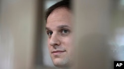 FILE - Wall Street Journal reporter Evan Gershkovich stands in a glass cage in a courtroom at the Moscow City Court in Moscow, Russia, on Oct. 10, 2023.