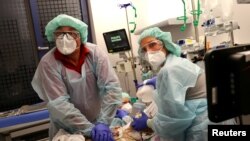 Dokter Katharina Franz dan paramedis Andreas Hankel, sedang mempersiapkan pengangkutan seorang pasien COVID-19. (Foto: Reuters)
