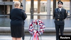 Norway's Prime Minister Erna Solberg, left, attends a wreath-laying ceremony near the government building that was bombed four years ago by gunman Anders Behring Breivik in Oslo, July 22, 2015. 