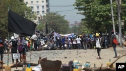 Manifestantes antigolpistas se preparan contra la represión policial en el municipio de Taketa en Yangon, Myanmar, el sábado 20 de marzo de 2021. (Foto AP)
